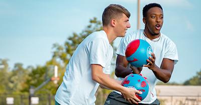 Two students playing sports on campus. 